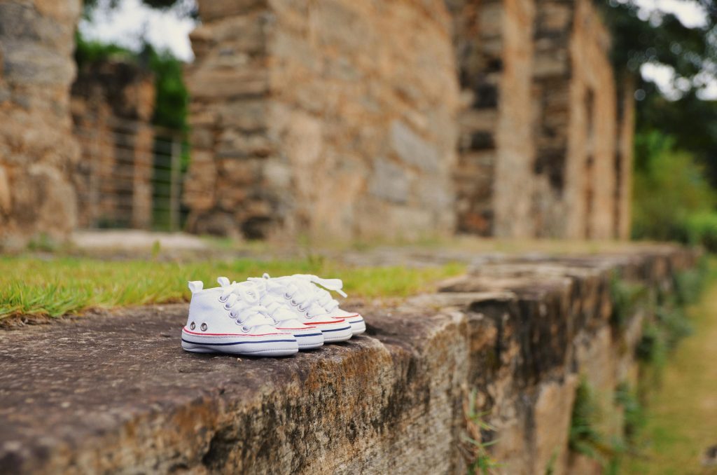 Pair of white sneakers placed on ancient stone ruins in Rio de Janeiro.